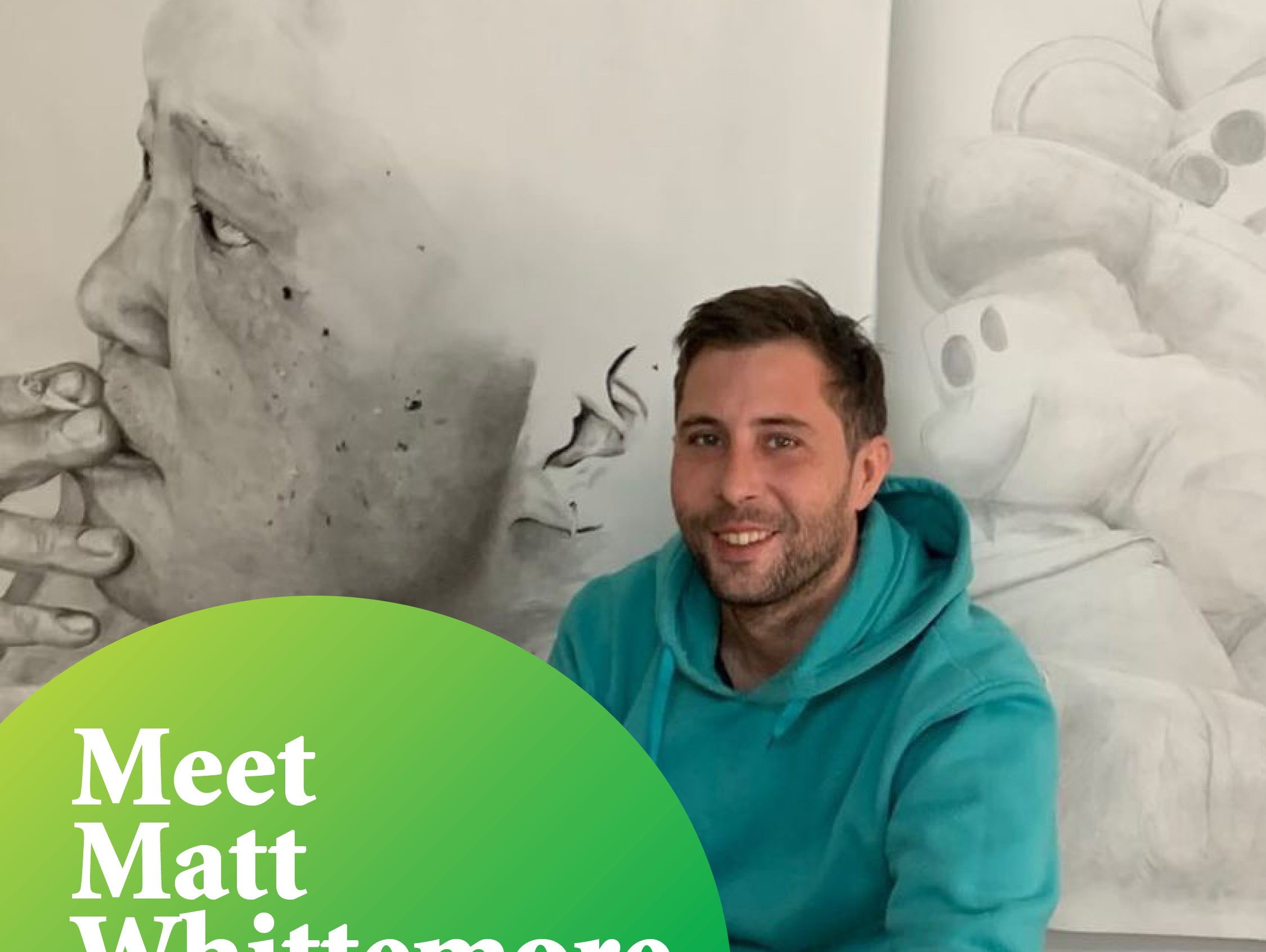 Pictured is Matt, smiling at the camera. He is wearing a teal hooded jumper and kneeling in front of two of his large, detailed, drawn artworks.