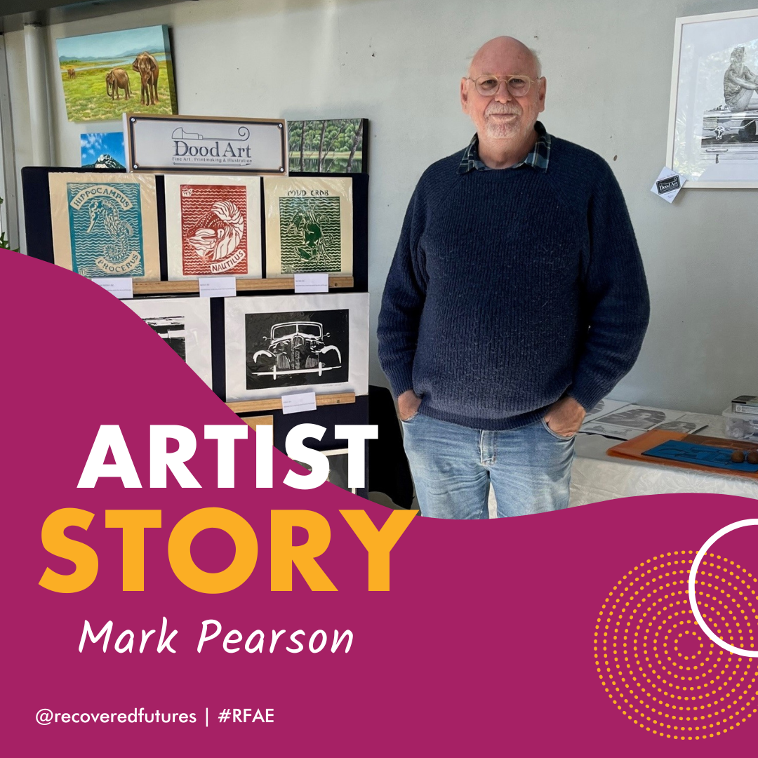 A photo of Mark Pearson, standing proudly next to a collection of his artworks.